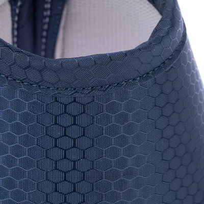 Gros plan sur un tissu bleu à motif hexagonal, couture visible. Matière synthétique avec doublure intérieure claire.