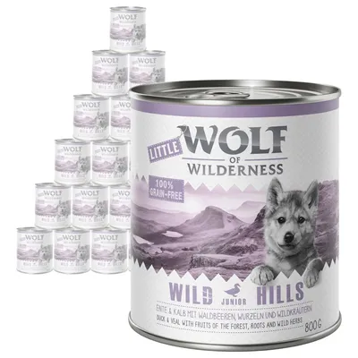 Little Wolf of Wilderness Wild Hills Junior 800g tin, visible text: 100% grain-free, duck & veal with fruits of the forest, roots and wild herbs. Multiple tins shown in background.