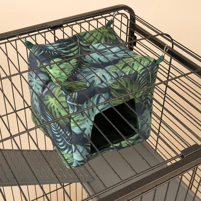 Hangmat met tropisch bladmotief, bevestigd aan metalen kooi. Ingang zichtbaar, geschikt voor kleine dieren.