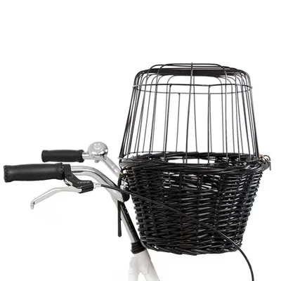 Cestino nero in vimini con griglia metallica di sicurezza montato sul manubrio di una bicicletta, impugnature nere e campanello visibili.