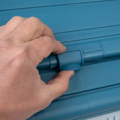 Detailní záběr ruky otevírající nebo zavírající modrý uzavírací mechanismus. Vhodné pro ukázku ovládání produktu.