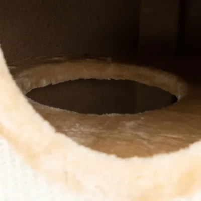 Detailný záber na okrúhly vchod s mäkkým, béžovým plyšovým poťahom, vhodný ako úkryt alebo miesto na spanie pre domáce zviera.