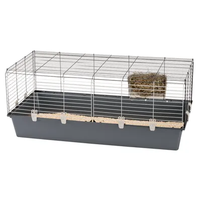 Kleintierkäfig mit grauer Kunststoffwanne, Metall-Gitterwänden und Heuraufe. Einstreu sichtbar am Boden.