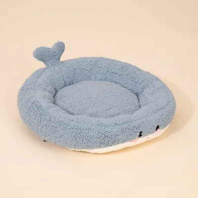 Rundes, blaues Bett aus Plüsch mit herzförmiger Schwanz-Applikation und aufgesticktem Gesicht an der Vorderseite.