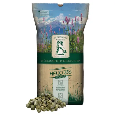 Mühldorfer Pferdefutter Heucobs staubfrei, ohne Melasse und Zuckerzusatz, Einspeicherung durch Wasser. Verpackung mit Berglandschaft und Wiesenmotiv.