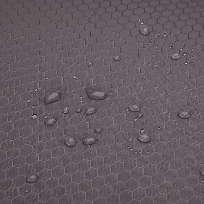 Superficie in tessuto sintetico grigio con motivo a nido d'ape e gocce d'acqua visibili.