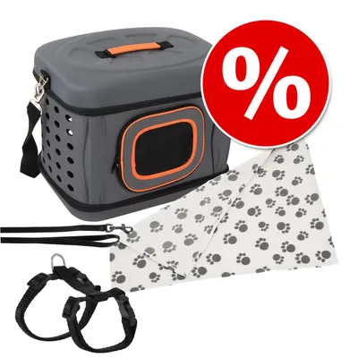 Set bestehend aus grauer Transportbox mit orangefarbenem Rand, schwarzem Geschirr und Leine sowie weißem Tuch mit Pfotenmuster. Rotes Rabattzeichen mit Prozent-Symbol sichtbar.