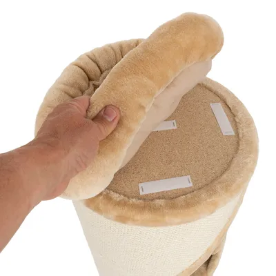 Hand hebt abnehmbaren, beige gepolsterten Bezug mit Klettverschlüssen von einer runden Kratzbaumplattform aus Holz.