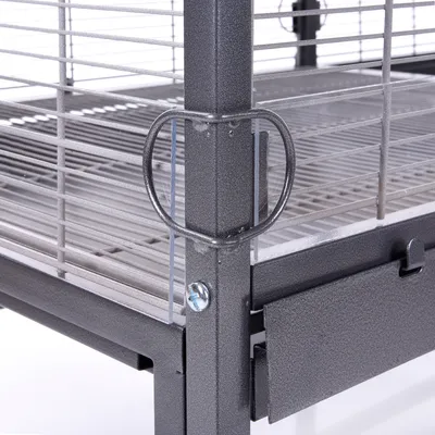 Detalle de jaula metálica para mascotas con rejilla horizontal y vertical, bandeja extraíble en la base y cierre lateral visible.