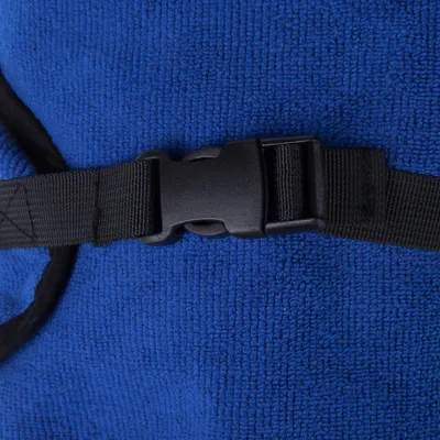 Detailní záběr na černou plastovou sponu na modré látce s černým popruhem.