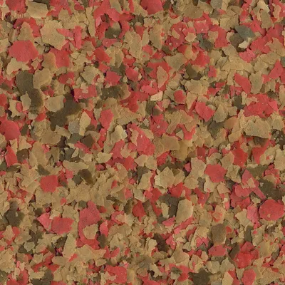 Primer plano de escamas de alimento rojo, marrón y verde para peces de acuario.