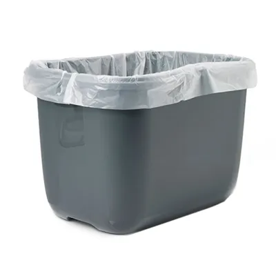 Contenedor de plástico gris con bolsa de basura blanca insertada, forma rectangular y asa lateral visible.