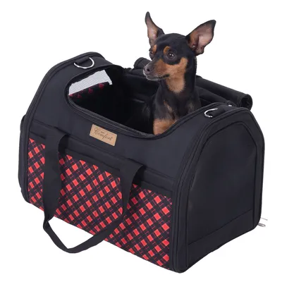 Sac de transport noir et rouge à motif carreaux, marque Comfort, avec un petit chien noir et feu assis à l’intérieur. Poignées en tissu et panneaux latéraux en maille visibles.