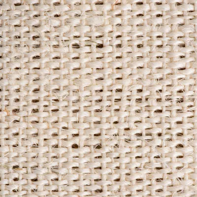 Gros plan sur une texture de tissu tissé beige, fibres naturelles visibles. Matériau : toile ou jute.