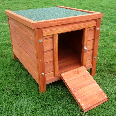 Wooden dog kennel with green roof, folding ramp and metal locks, placed on a lawn.