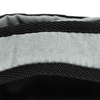 Detailní záběr na šedý textilní materiál s černou síťovinou a zesíleným okrajem.