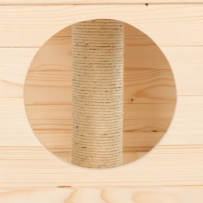 Klösträd av ljust trä med pelare lindad med sisal, synlig genom ett runt öppning.