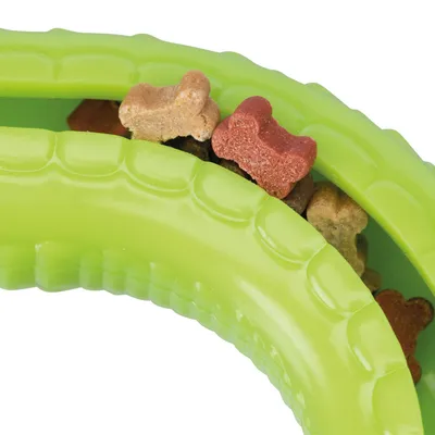 Giocattolo verde con snack a forma di osso in diversi colori, tra cui rosso, marrone e beige.