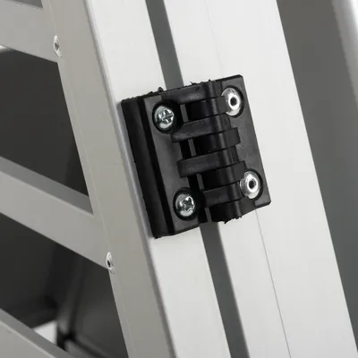 Detailní záběr na černý plastový pant se dvěma šrouby na stříbrném kovovém rámu.