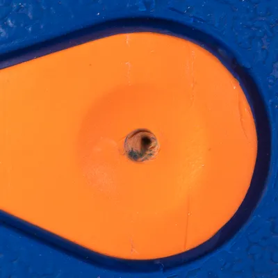 Close-up of an orange and blue toy with a central hole, suitable for interactive play.
