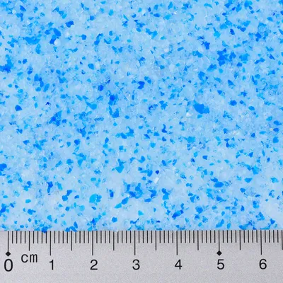 Close-up of blue and white granules with a ruler showing size in centimetres from 0 to 6 cm at the bottom edge