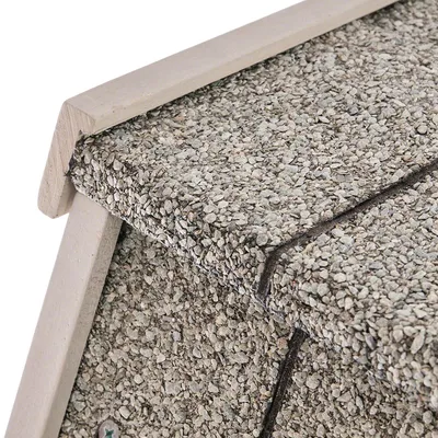 Detailweergave van een dak met grijze kiezelcoating en houten frame, geschikt voor weerbestendige dierenhuizen.
