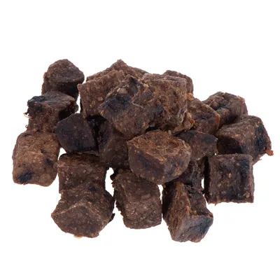 Morceaux de friandises brunes en forme de cubes, sans emballage visible, présentés en tas sur fond blanc.
