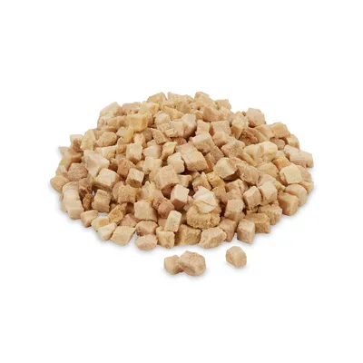 Cubi di snack per pet, colore beige chiaro, disposti in un mucchio su sfondo bianco. Nessun marchio o testo visibile.