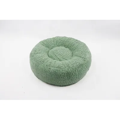 Cuscino rotondo per pet in tessuto verde con superficie morbida e struttura imbottita visibile.
