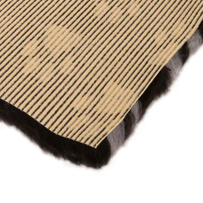 Nahaufnahme einer gestreiften beige-schwarzen Matte mit weicher, schwarzer Unterseite. Materialstruktur und Schichtung sichtbar.