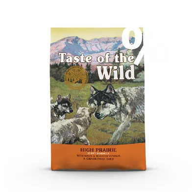 Taste of the Wild High Prairie Puppy Formula, scritta visibile: with bison & roasted venison, a grain-free diet. Immagine di lupi su sfondo naturale.