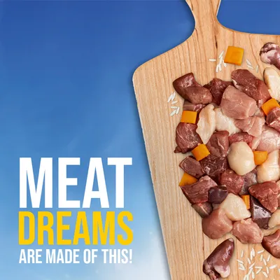 Texto en inglés: MEAT DREAMS ARE MADE OF THIS! Trozos de carne cruda, grasa, arroz y dados naranjas sobre tabla de madera. Texto no disponible en español.