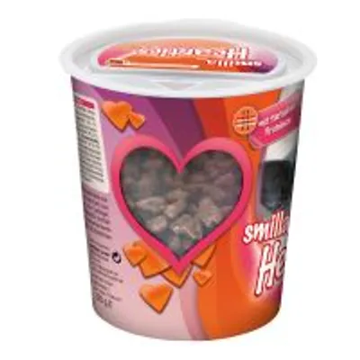 Opakowanie przysmaków dla zwierząt z okienkiem w kształcie serca, przez które widać kawałki karmy. Widoczny fragment napisu: 'smill... Hea...'.