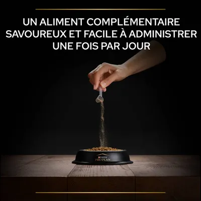 Main versant une poudre sur des croquettes dans une gamelle Purina Pro Plan. Texte : Un aliment complémentaire savoureux et facile à administrer une fois par jour.
