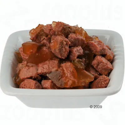 Primo piano di pezzi di carne in gelatina, serviti in una ciotola bianca.
