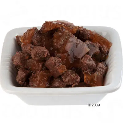 Primo piano di cibo umido in una ciotola bianca, composto da pezzi di carne in gelatina.