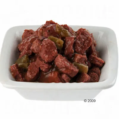 Ciotola bianca con bocconcini umidi di carne e pezzi verdi in salsa, alimento per pet visibile senza confezione.