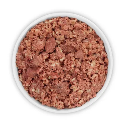 Primer plano de comida húmeda roja en un cuenco blanco, compuesta de trozos de carne e ingredientes triturados.