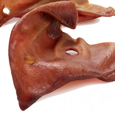 Image shows dried pig ears as a natural chew treat, displayed on a white background.