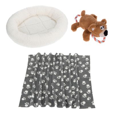 Set per animali: coperta grigia con impronte bianche, peluche a forma di orso con corda e cuccia rotonda bianca in tessuto. Simbolo percentuale arancione indica offerta o sconto.