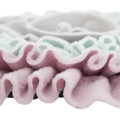 Gros plan sur un tissu à volants rose et vert clair, matière en textile doux. Aucun logo ni texte visible.