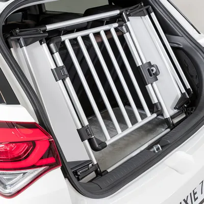Transportbox aus Aluminium und Kunststoff, installiert im Kofferraum eines Autos. Geeignet für sichere Tierbeförderung.