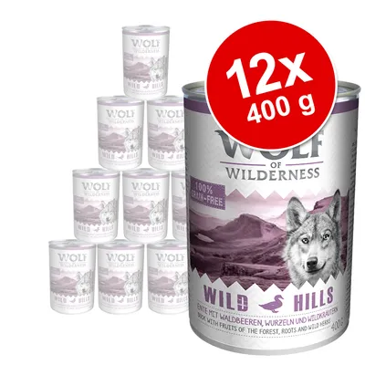 Wolf of Wilderness Wild Hills -koiran märkäruoka, 12 x 400 g. Etiketissä teksti: 100% grain-free. Pakkauksessa susi ja vuoristomaisema.