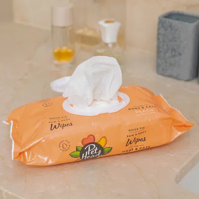 Мокри кърпички Pet Head Quick Fix Paw & Body Wipes за кучета и котки, аромат на праскова с алое вера. Оранжева опаковка с отворена капачка и видима кърпичка.
