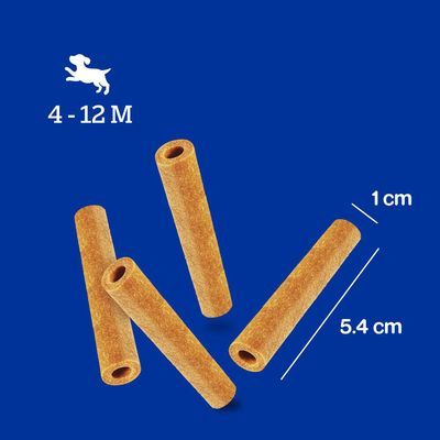 Afbeelding van vier holle staafvormige hondensnacks, lengte 5,4 cm en diameter 1 cm. Pictogram hond met tekst: 4–12 M.