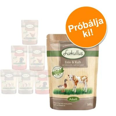 Lukullus Ente & Kalb 300 g, Adult. Próbálja ki! Felirat egy narancssárga körben a csomagoláson. Háttérben további Lukullus tasakok homályosan.