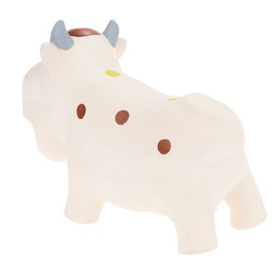 Λευκό παιχνίδι σε σχήμα αγελάδας με καφέ και κίτρινες βούλες και μπλε κέρατα, κατασκευασμένο από πλαστικό υλικό.