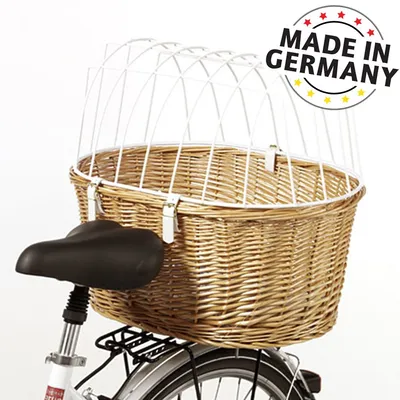 Cestino in vimini con griglia metallica bianca montato su portapacchi di bicicletta, testo visibile: MADE IN GERMANY