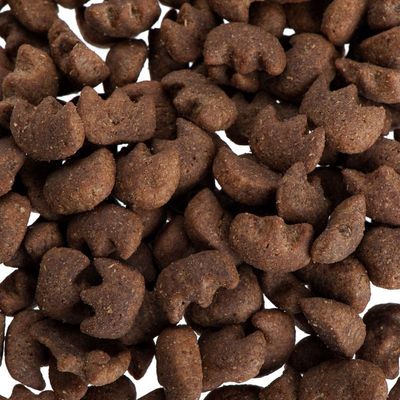 Detail tmavě hnědých granulí ve tvaru kočičí hlavy, bez viditelné značky nebo textu.