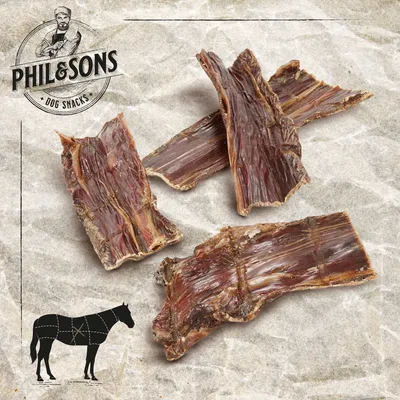 Phil & Sons Dog Snacks. Getrocknete Pferdefleischstreifen auf hellem Hintergrund, geeignet als Hundesnack. Phil & Sons Dog Snacks. Getrocknete Pferdefleischstreifen auf hellem Hintergrund, geeignet als Hundesnack.
